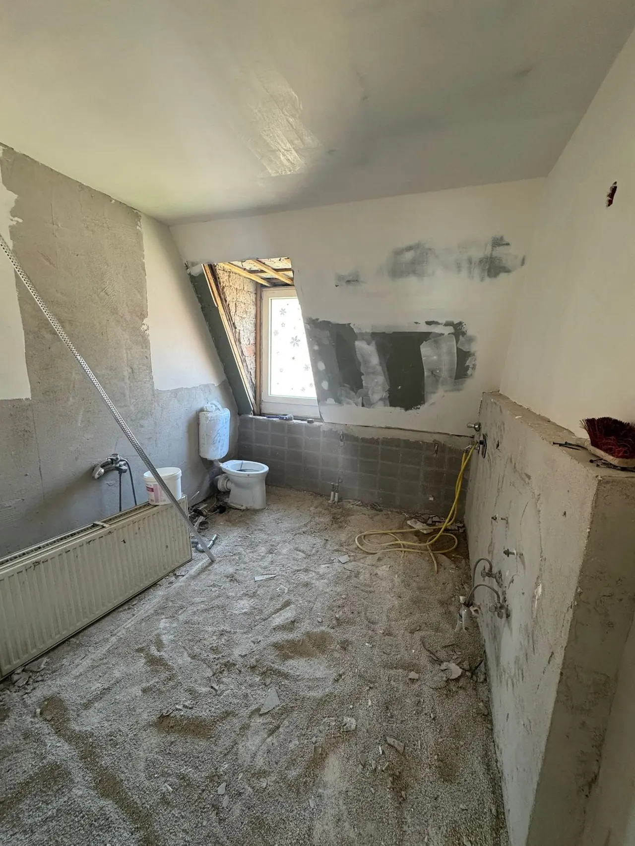 Nürnberg, Badezimmer vor der Sanierung: Rohzustand mit offenen Leitungen, abgeschlagenen Wandflächen und Bauschutt