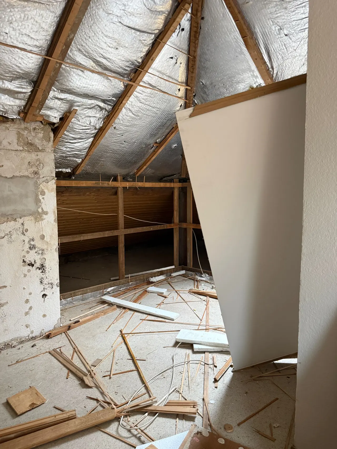 Freigelegte Dachkonstruktion mit Dämmfolie und Holzsparren als Vorbereitung für den Neuaufbau